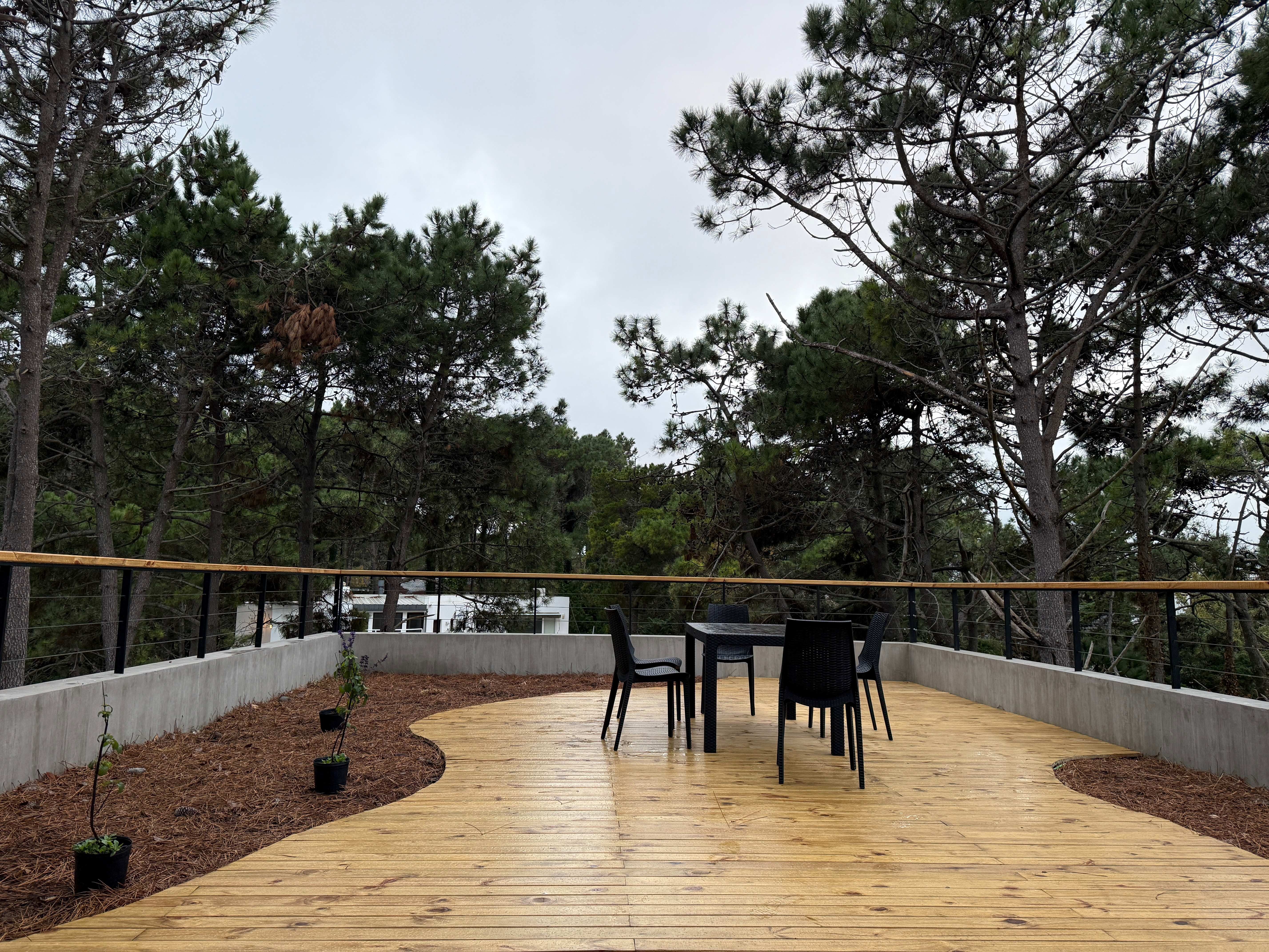 Wooden deck terrace with outdoor dining furniture and pine forest views